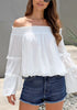 Front view of model wearing white bell sleeves dotted loose off-shoulder top