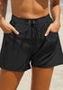 Front view of model wearing black elastic-waist side pockets lace-up board shorts