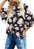 Front view of model wearing black trumpet sleeves keyhole-back printed blouse