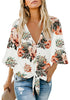 Front view of model wearing white V-neckline button-up tie-front floral top