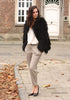 Full angled view of model in black faux fur coat with white top and pants