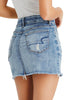 Back view of model wearing light blue frayed raw hem ripped denim mini skirt