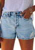 Front view of model wearing light blue mid-waist distressed washed denim shorts