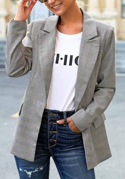Model poses wearing grey plaid lapel front-button side-pockets blazer