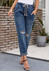 Model poses wearing dark blue drawstring-waist cuffed ripped boyfriend jeans