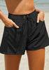 Model poses wearing black elastic-waist side pockets lace-up board shorts