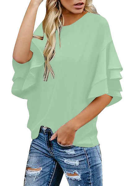 Angled shot of model wearing mint green trumpet sleeves keyhole-back blouse