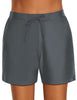 Front view of model wearing dark grey lace-up board shorts