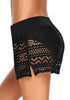Side view of model in black hollow out side-slit drawstring swim shorts