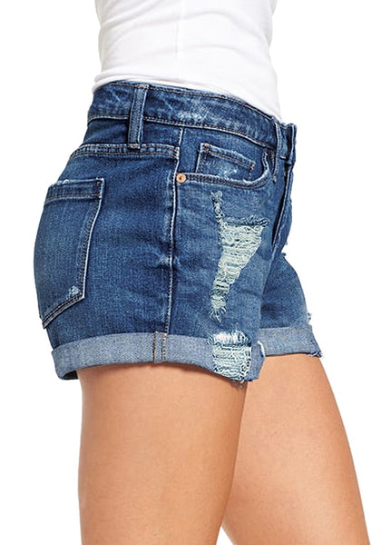 Side view of model in blue roll-over hem button-up distressed denim shorts