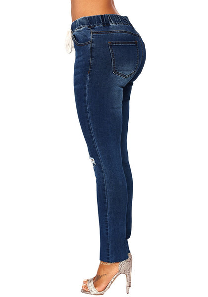 Side view of model wearing dark blue drawstring-waist washout ripped skinny jeans