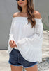 Side view of model wearing white bell sleeves dotted loose off-shoulder top