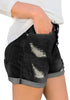 Side view of model wearing black roll-over hem button-up ripped denim shorts