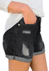 Side view of model wearing black roll-over hem ripped denim shorts