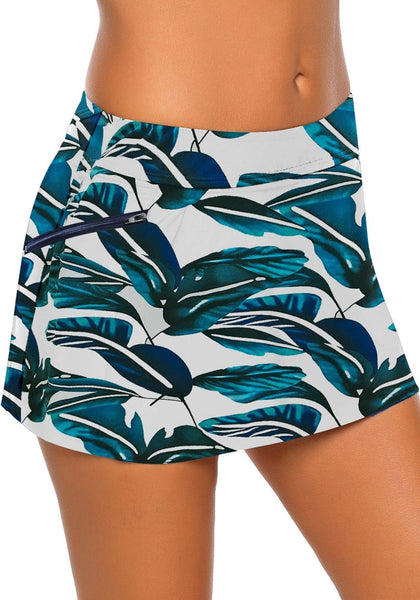 Side view of model wearing blue zipper-pocket waistband leaves-print skirted bikini bottom