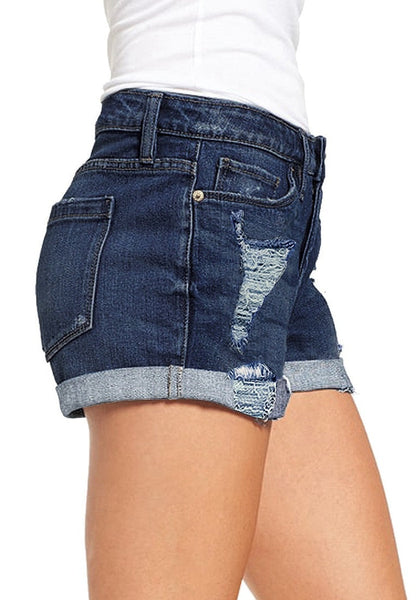 Side view of model wearing dark blue roll-over hem button-up distressed denim shorts